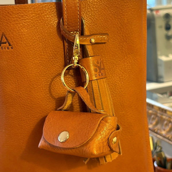 Detail van bagcharm en kwast bij leren tote