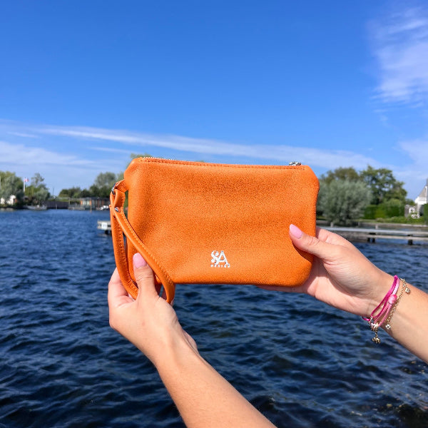 Oranje etui in de hand