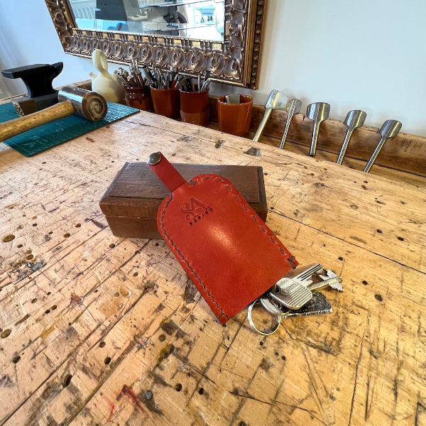 Achterkant van de Leren sleutelhoes uit de workshop leren accessoire maken van SA Design op de werkbank met sleutels