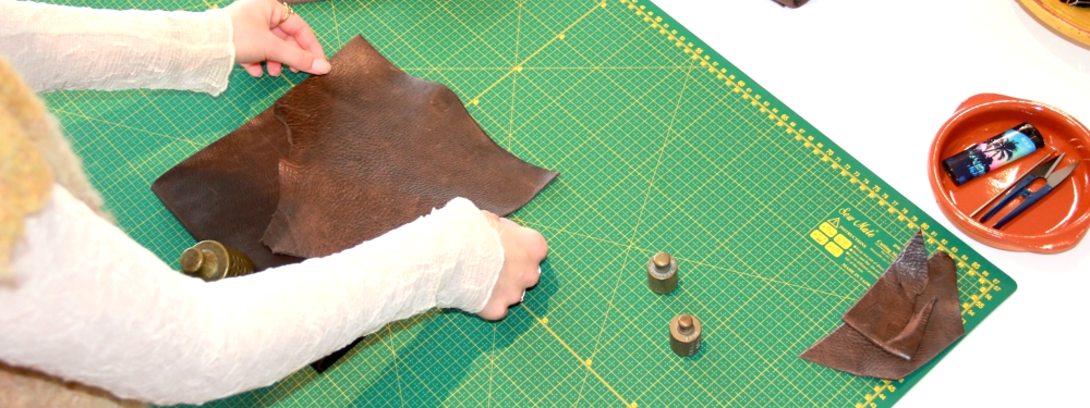 Bovenaanzicht van werkbank van cursist die aan het passen en meten is in de workshop kleine leren tas van SA Design