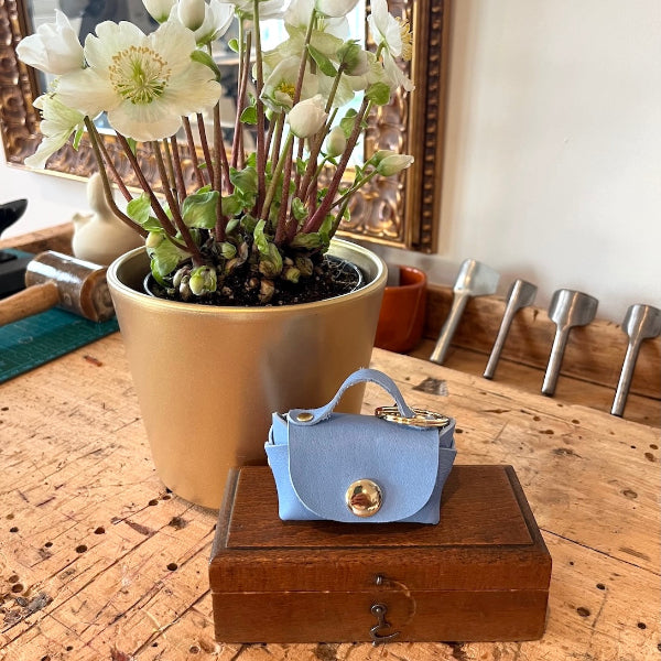 Bag charm in lichtblauw op de werkbank in het leeratelier van SA Design
