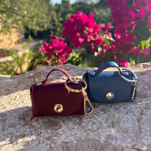 Bag charms in bordeaux en blauw op stenen muurtje