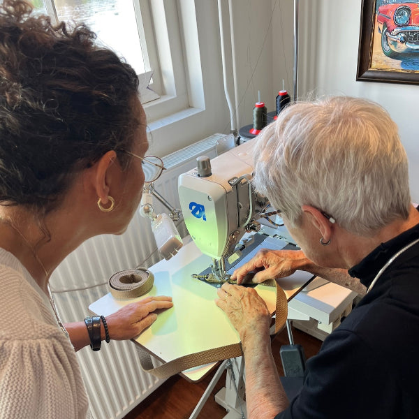 Begeleiding bij naaien op de machine in workshop leren tas