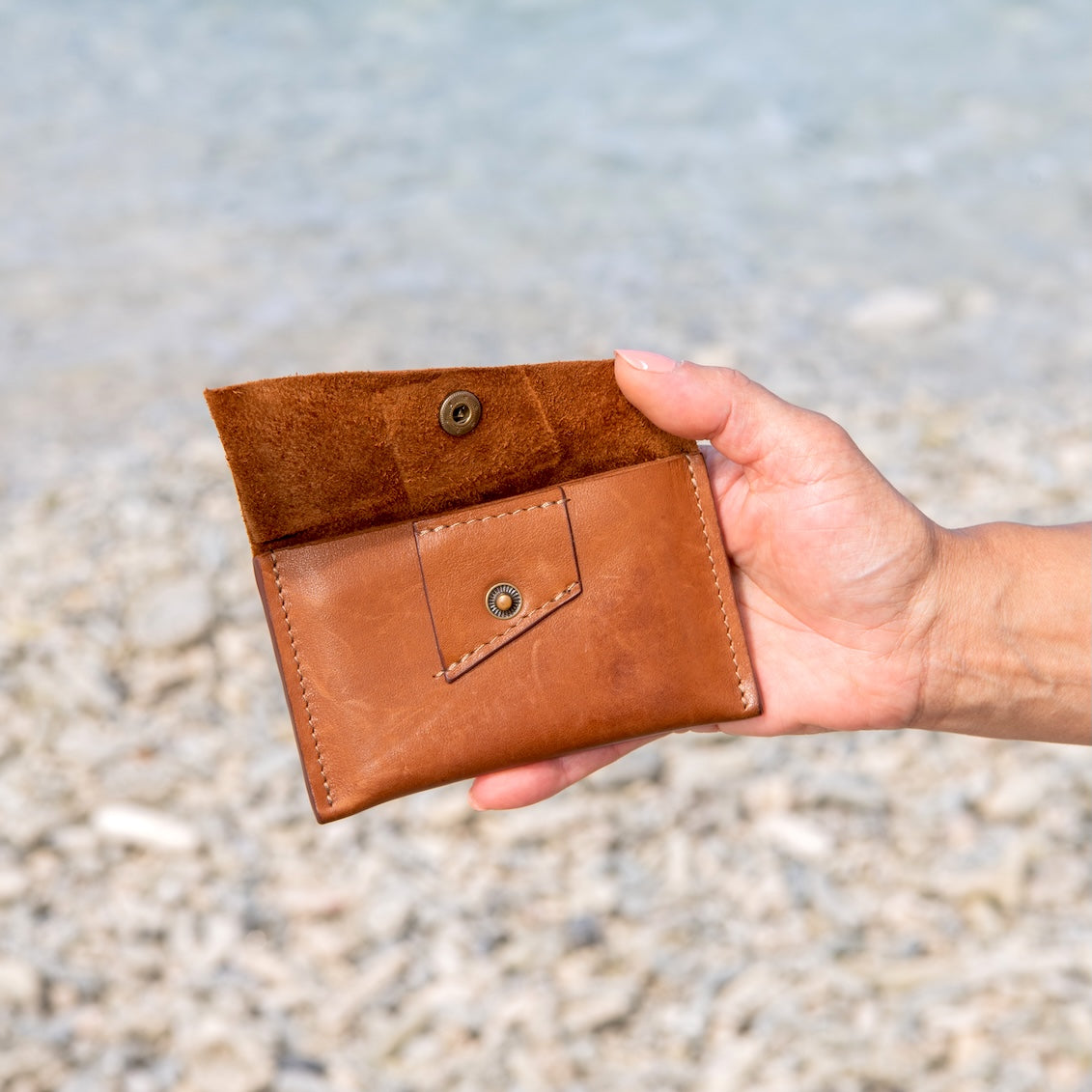 Pasjeshouder in de hand zodat je formaat goed kunt zien