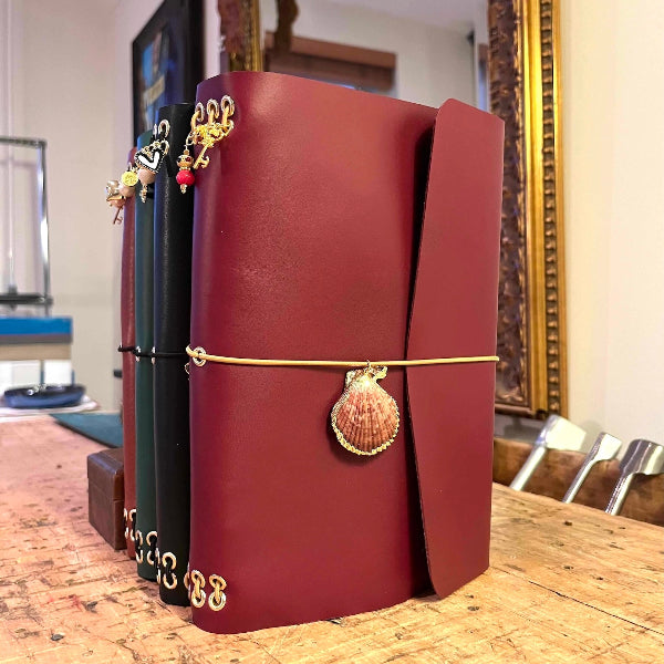 Notebook A5 met goudvergulde bedels rechtopstaand in bordeaux