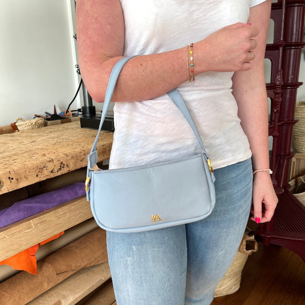 Zelgemaakte croissant bag in lichtblauw in workshop kleine leren tas