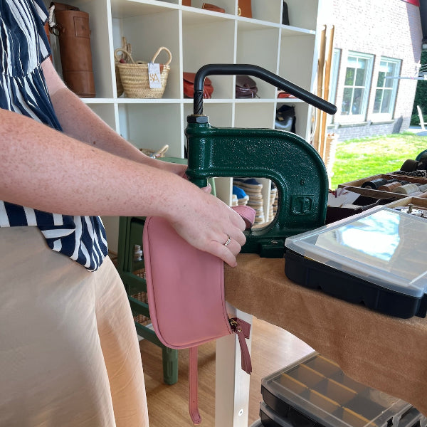 Gaatjes maken in roze tas in workshop leren tas