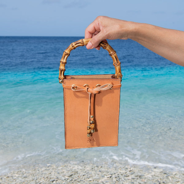Leren crossbody tas uit de Madrid Bambu collectie boven het water gehouden