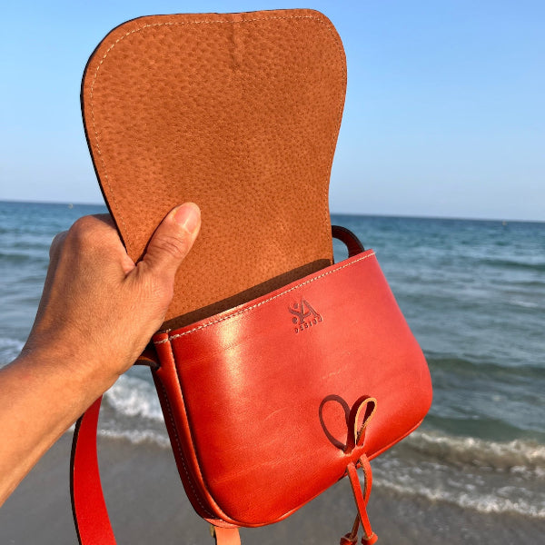 Crossbodytas sevilla in de hand aan zee in cognac
