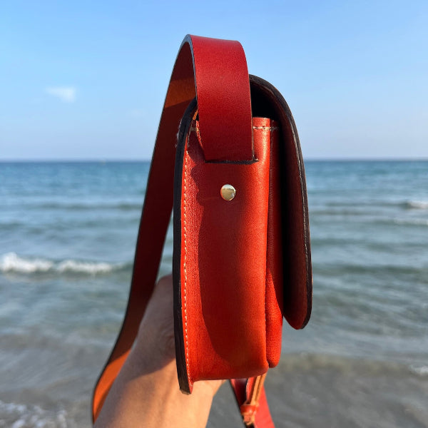 Zij aanzicht van de crossbody tas Sevilla in cognac rechtopstaand 