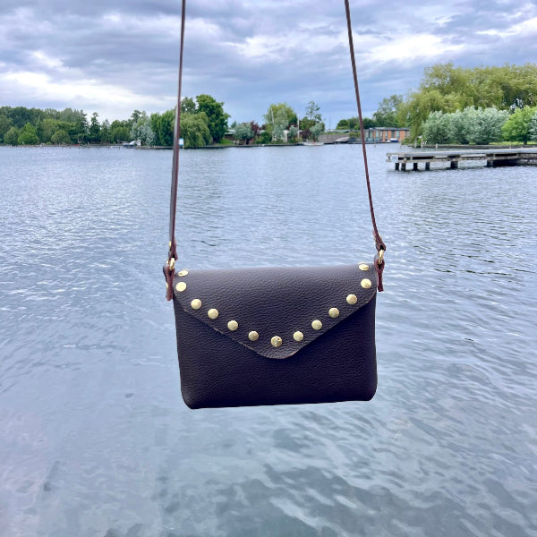 Crossbody tas in donkerbruin met studs op de flap