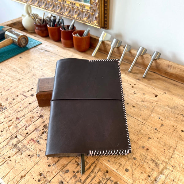 Eindresultaat van donkerbruine notebook met roze garen uit workshop van SA Design
