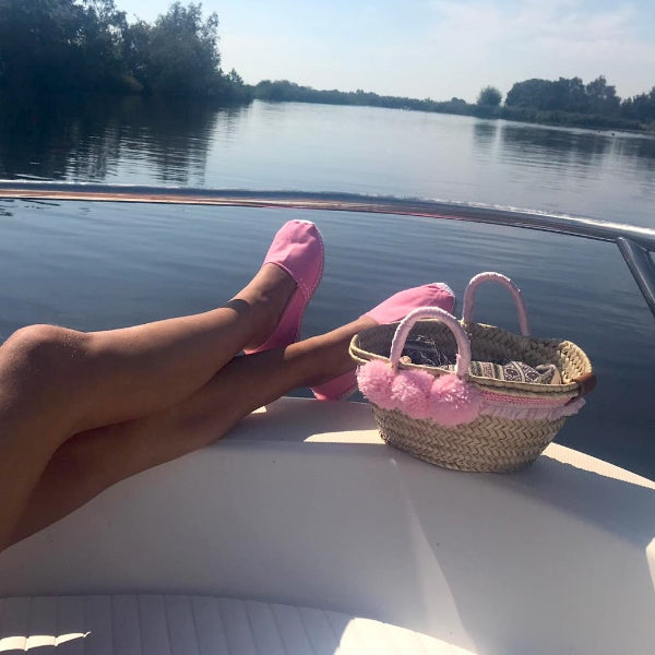Roze espadrilles aan de voet in een boot