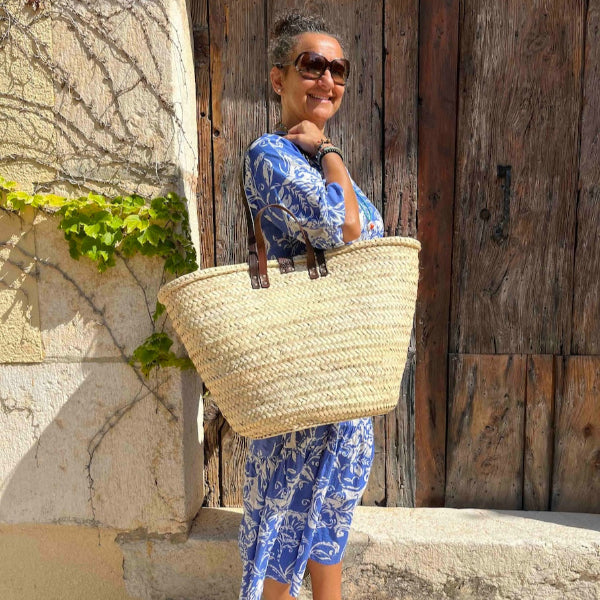 Grote rieten strandtas uit de Valencia collectie aan de schouder van Nina