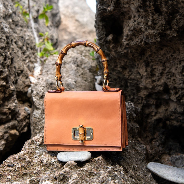 Handgemaakte leren handtas in camel uit de Bamboe collectie op een rots