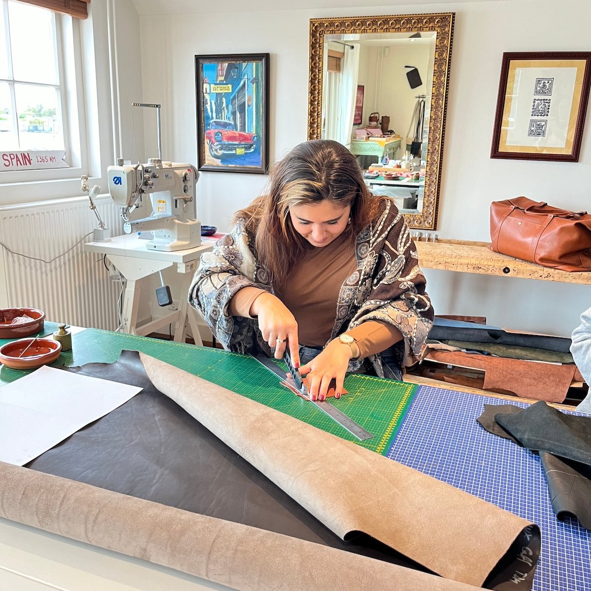 Cursist snijdt het leer uit bij de cursus leren tas maken in atelier 