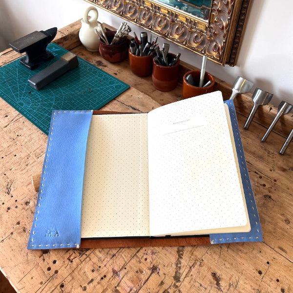 Binnenzijde van een handgemaakte leren notebookcover van geitenleer met een binnenkant van lichtblauw kalfsleer