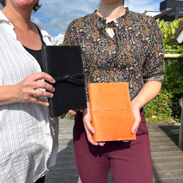 Leren notebooks in de hand op de steiger van atelier van SA Design