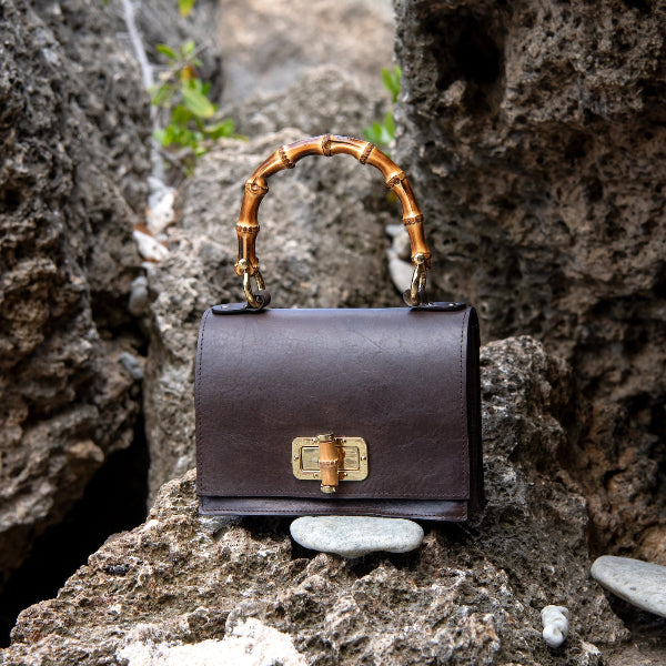 Handgemaakte leren handtas in donkerbruin uit de Bamboe collectie op een rots