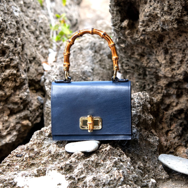 Handgemaakte leren handtas in navy uit de Bamboe collectie op een rots