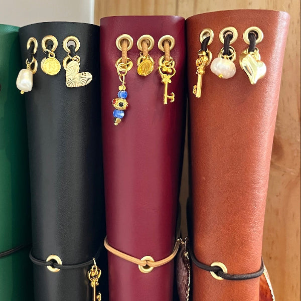 Leren notebooks in cognac, goud en bordeaux met goudvergulde bedels