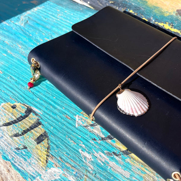 Leren notebook in donkerblauw met bedels op een bankje
