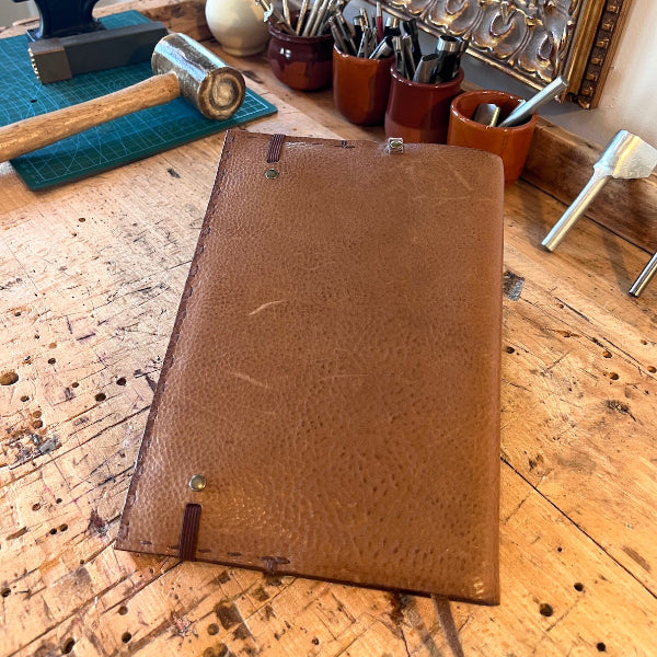 Handgemaakte leren notebook van natuurlijk gelooid leer met elastiek aan de achterkant voor het sluiten van de notebook