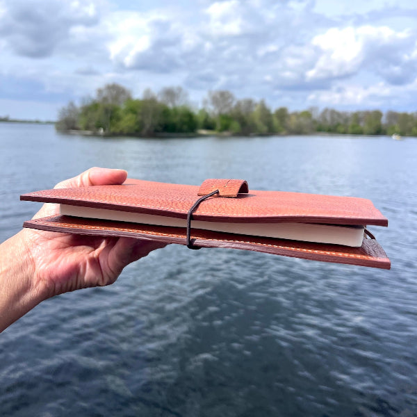 Gepersonaliseerde leren notebook gefotografeerd vanaf de zijkant