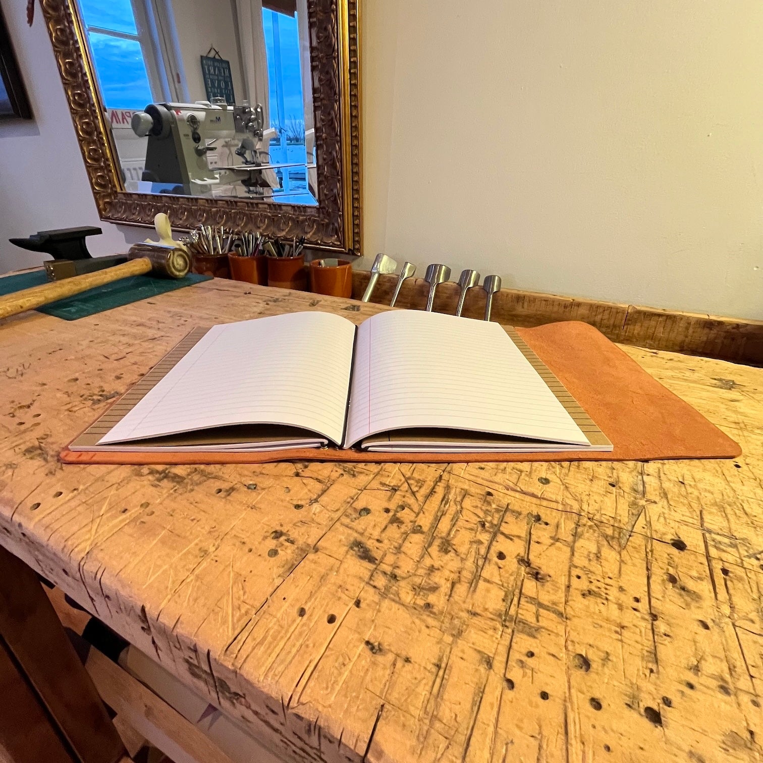 Leren notebook voor schriften opengeslagen op werkbank