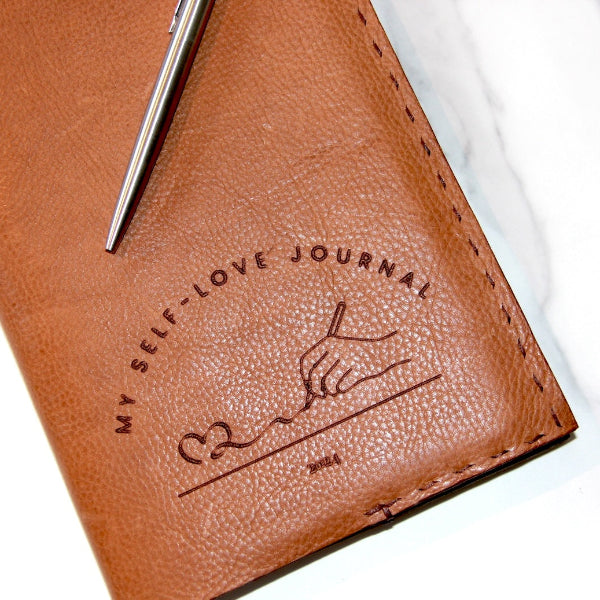 Handgemaakte leren notebook cover in zand met logo 