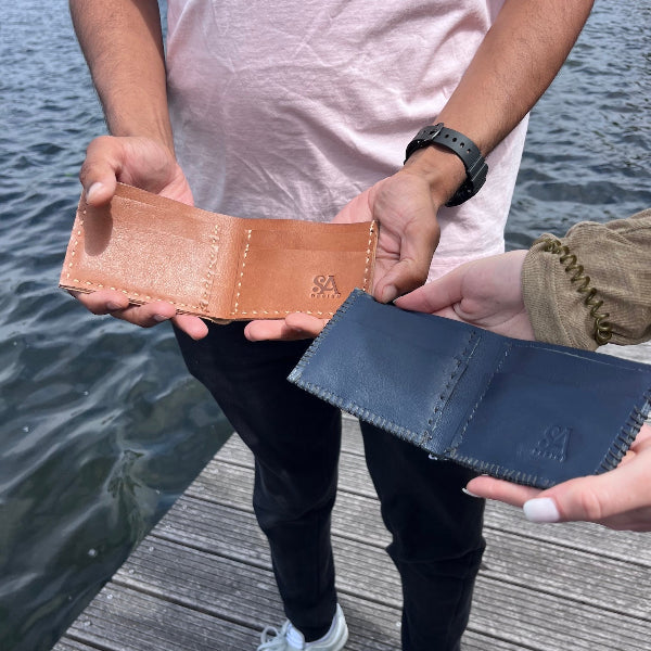 Eindresultaat van een handgemaakte leren portefeuille uit de workshop in blauw en cognac
