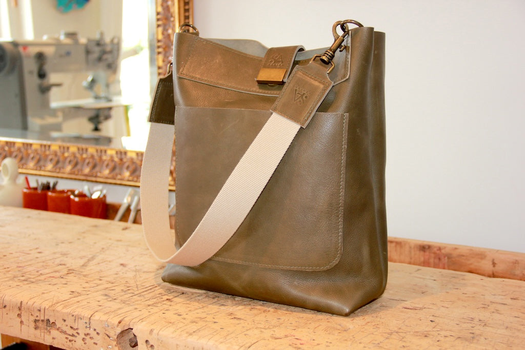 Leren schoudertas in olijfgroen op de werkbank van SA Design