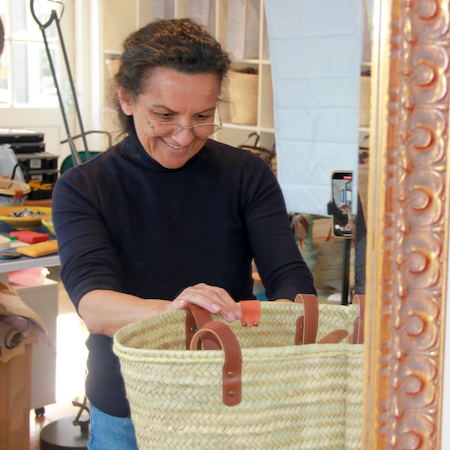 Nina die in atelier een Sevilla rieten tas maakt