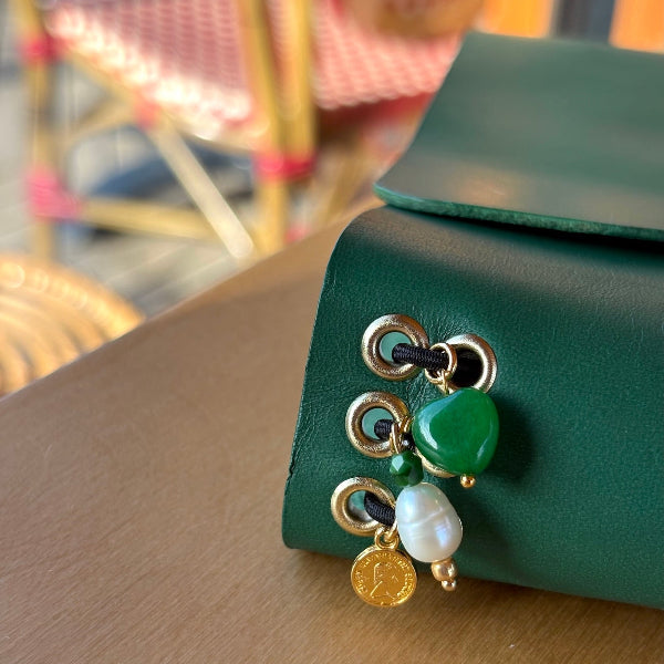 Notebook A5 met goudvergulde bedels in groen op een tafel met de detail van de bedels