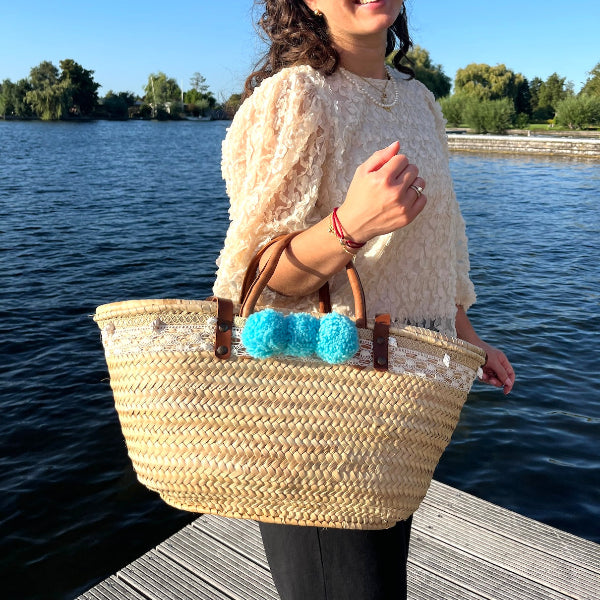 Rieten strandtas die je aan de arm en als schoudertas kunt dragen met kant, schelpen en aqua pompons