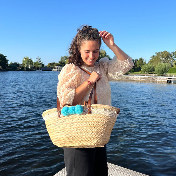Rieten strandtas die je aan de hand en ook als schoudertas kunt dragen met kant, schelpen en aqua pompons