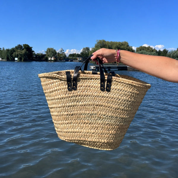 Achterzijde rieten strandtas in medium formaat gedragen aan handvatten