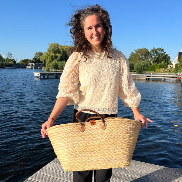 Sofia met de extra grote rieten tas uit de Valencia collectie in de hand op de steiger