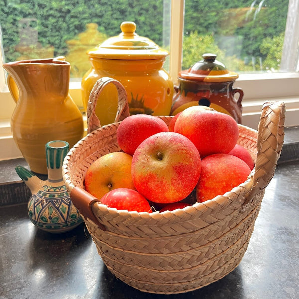 Rieten tasje klein in de keuken gevuld met rode appels