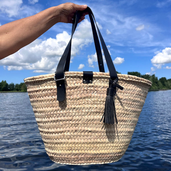 Voorkant van de handgemaakte rieten tas uit de Sevilla collectie met zwarte leren hengsels en details