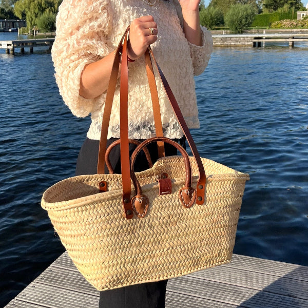 Sofia met de grote rieten tas uit de Valencia collectie met hengsels  in de hand op de steiger details