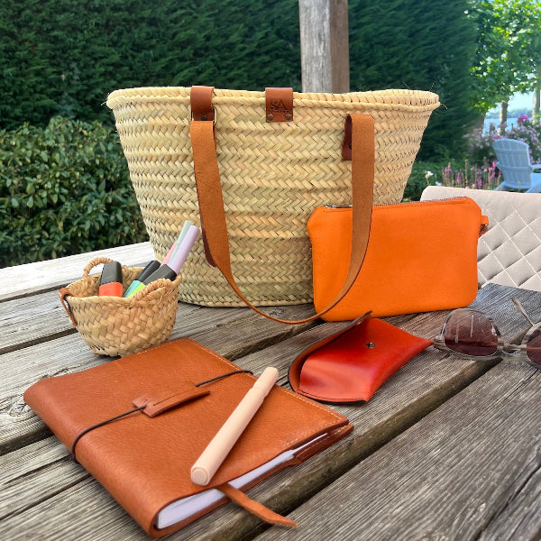 Tafel met leren accessoires en rieten tas