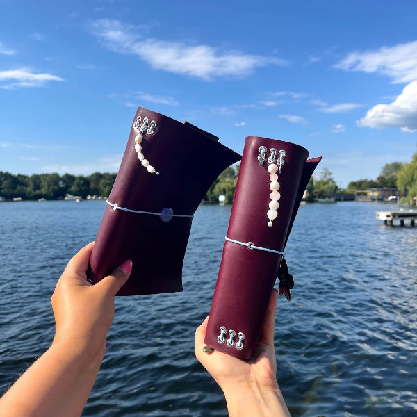 Achterzijde met bedels van Twee vriendinnen met gepersonaliseerde notebooks in aubergine kleur