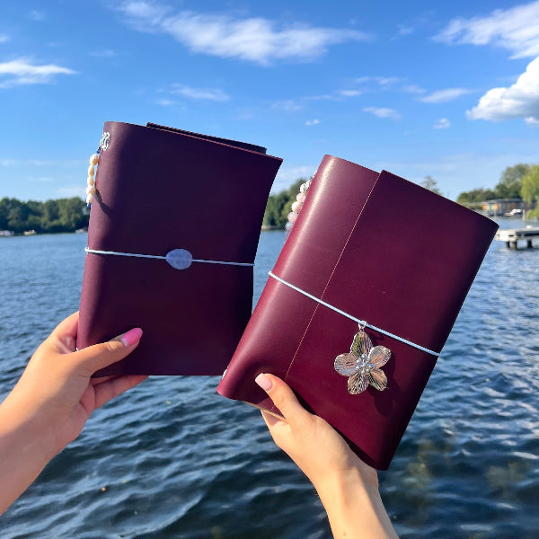 Voorzijde van notebooks van Twee vriendinnen met gepersonaliseerde notebooks in aubergine kleur