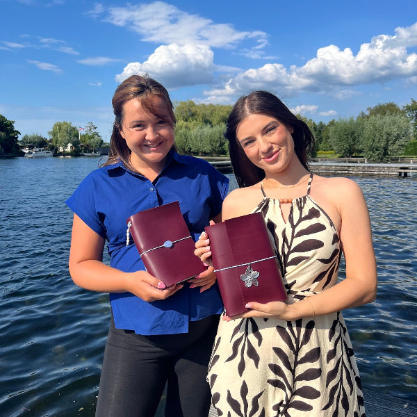 Twee vriendinnen met gepersonaliseerde notebooks in aubergine kleur