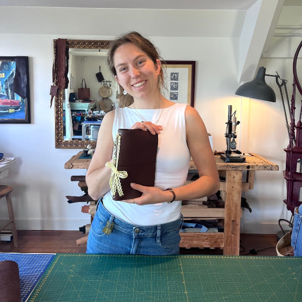 Leren notebook in donkerbruin in de hand in het atelier in de workshop gepersonaliseerde leren notebook cover maken
