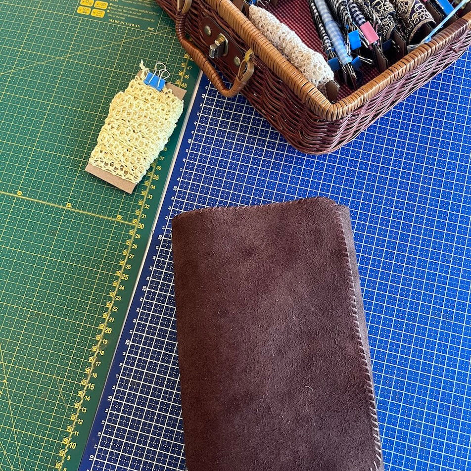 Gepersonaliseerde notebook in donkerbruin suede met stiksel in bruin uit de workshop gepersonaliseerde leren notebook cover maken