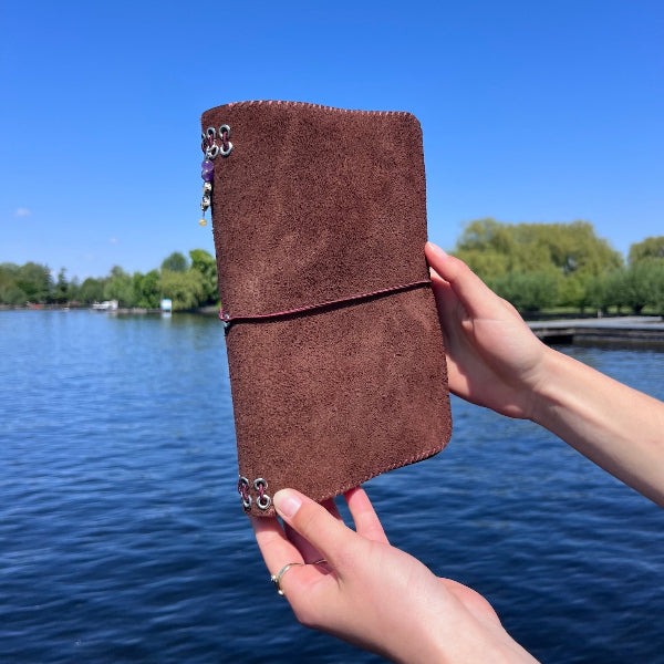 Eindresultaat op de steiger van eeGepersonaliseerde notebook in donkerbruin suede met stiksel in bruin uit de workshop gepersonaliseerde leren notebook cover maken 