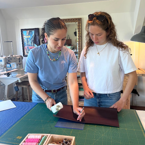 Uitleg over het maken van gaatjes in de workshop gepersonaliseerde leren notebook cover maken