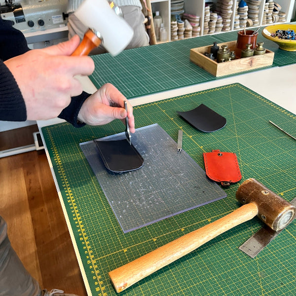 Gaatjes maken in donkerblauwe sleutelhoes